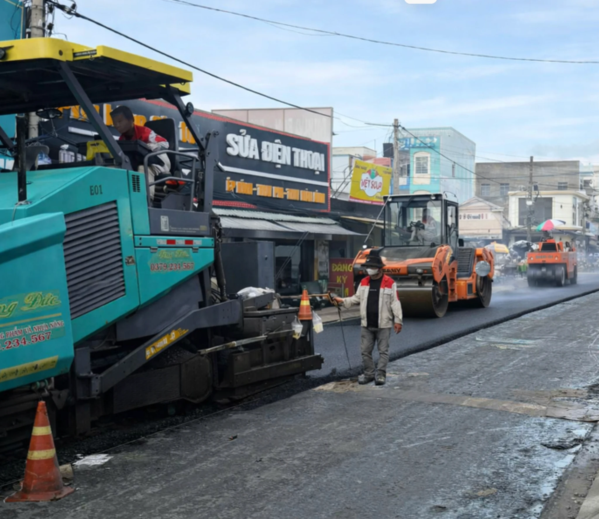 Long Duc asphalt paving crew and roller operation on site