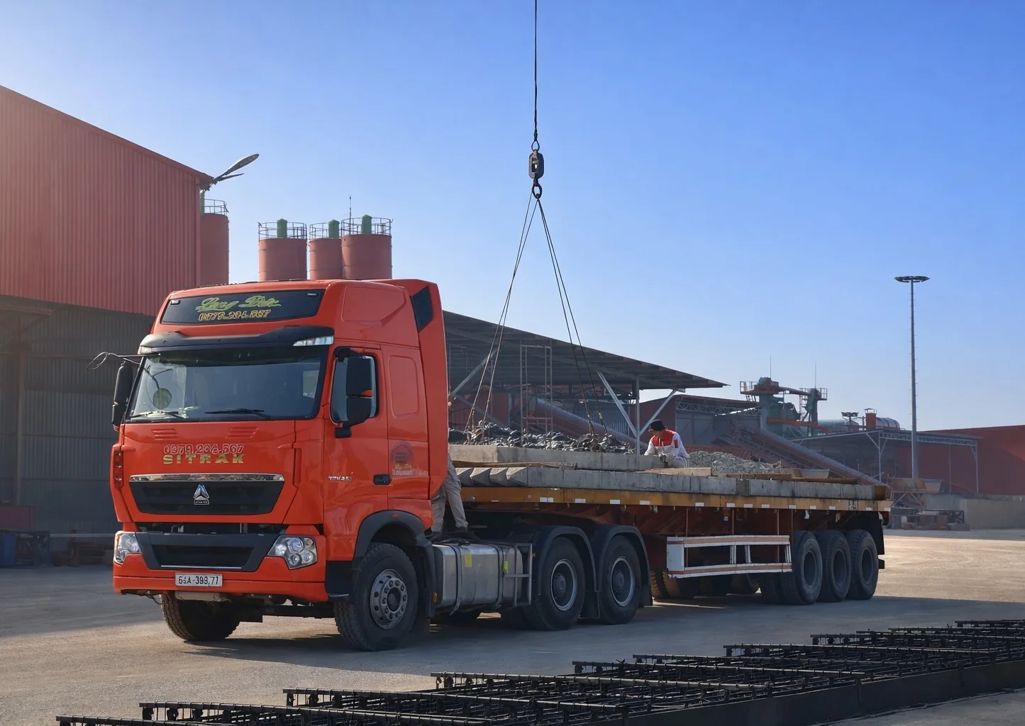 Red truck delivering concrete piles at Long Duc yard